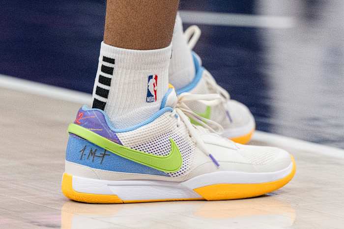 Detroit Pistons forward Tosan Evbuomwan's white and green Nike shoes.